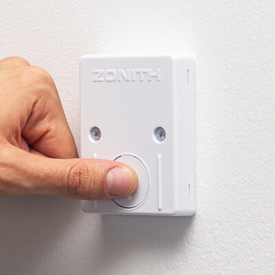 Person pressing the wireless fixed mounted ZONITH alarm button.